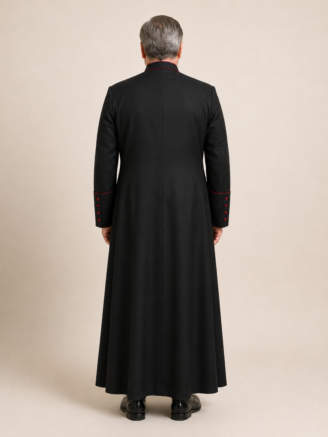 Back view of a black men's clergy cassock with red-piped seams and covered red buttons