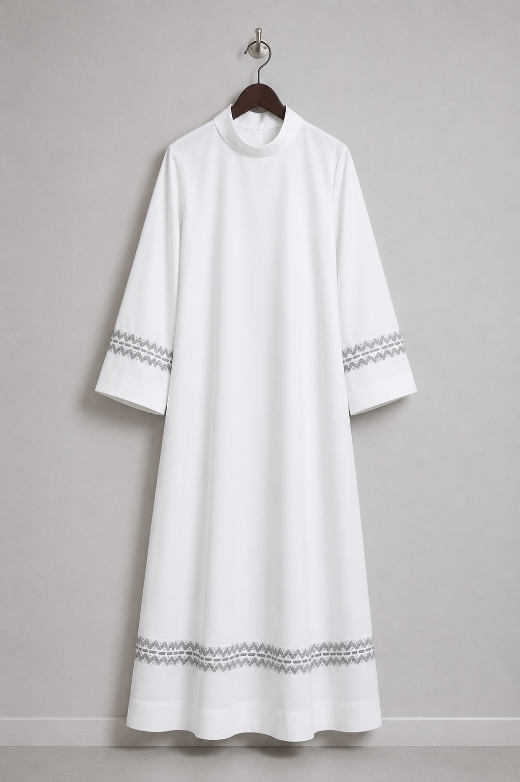 White women's clergy alb with woven ornamental trim on the sleeves and lower hem